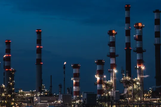 Oil refinery illuminated at night showcasing energy sector infrastructure